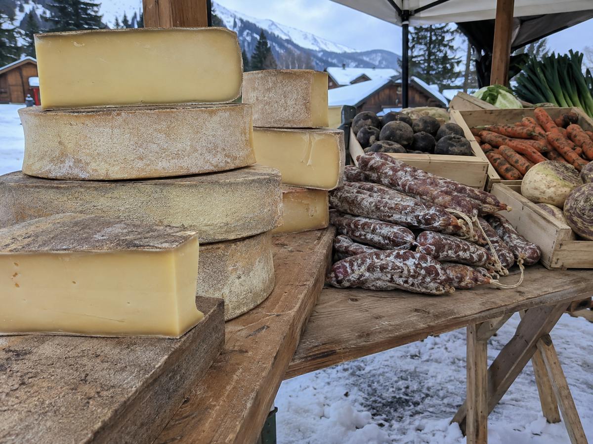 Meules de Beaufort et charcuterie sur un marché de Tarentaise